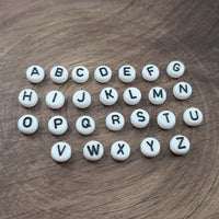 Perles blanches avec lettres noires