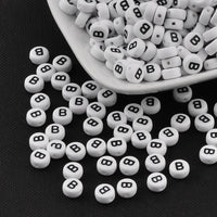 Perles blanches avec lettres noires